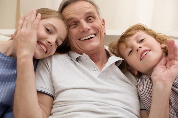 Photo cheerful smiling handsome man sharing a happy moment and expressing his love while his kids visiting him on the weekend