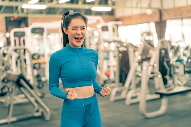 Donna sportiva sorridente allegra nella palestra di forma fisica