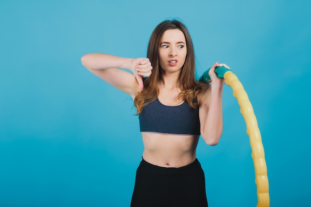 cheerful sport girl with hula hoop on blue background