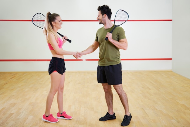 Giocatori di squash allegri che si stringono la mano