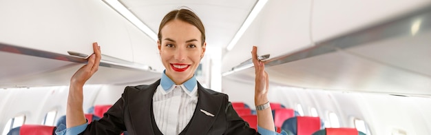 Foto hostess allegra in piedi nel salone del passeggero dell'aeroplano