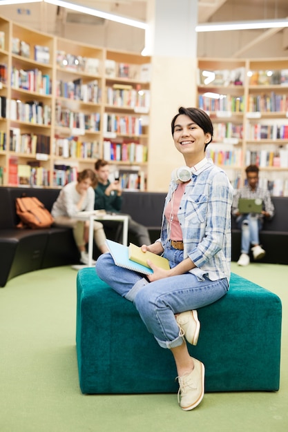 Cheerful student girl in modern library