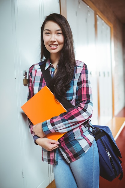 Cheerful student standing next the locker