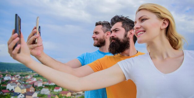 Cheerful students on vacation having fun doing photo by sky back