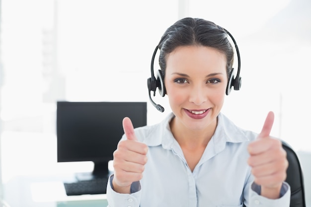 Cheerful stylish brunette operator giving thumbs up