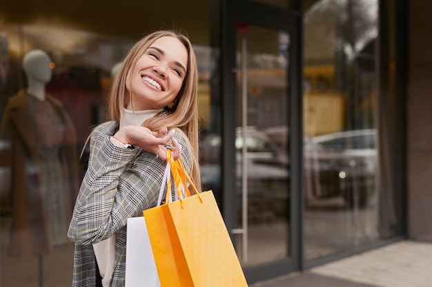 Cheerful stylish woman with shopping bags