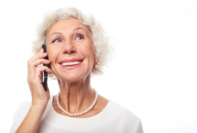 陽気で成功した60歳の高齢の女性が電話で話しています