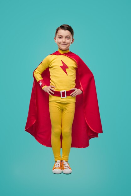 Cheerful superhero boy in bright costume