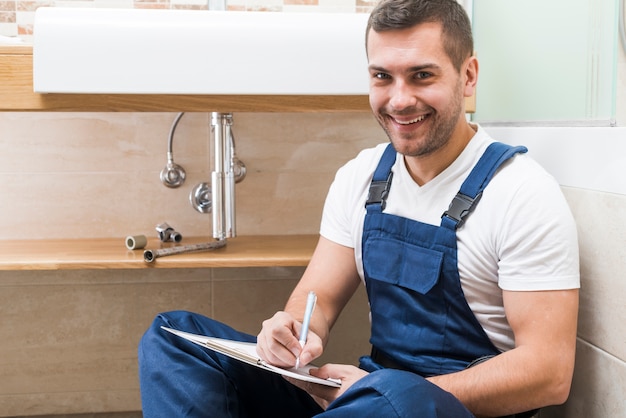 Cheerful technician writing in tablet