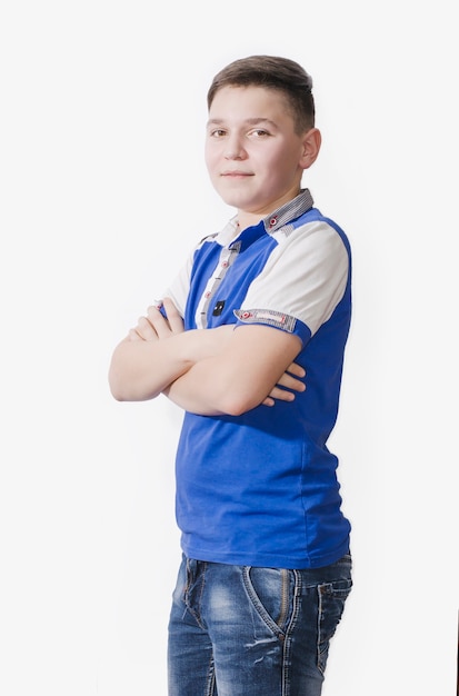 Cheerful teen in a blue shirt on a white surface