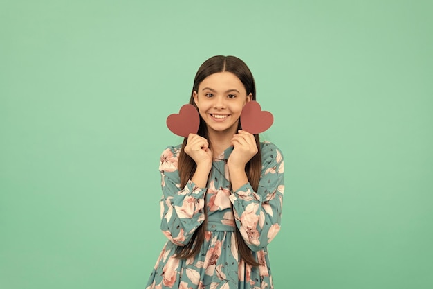 Cheerful teen girl hold red heart symbol of love for valentines day valentines day