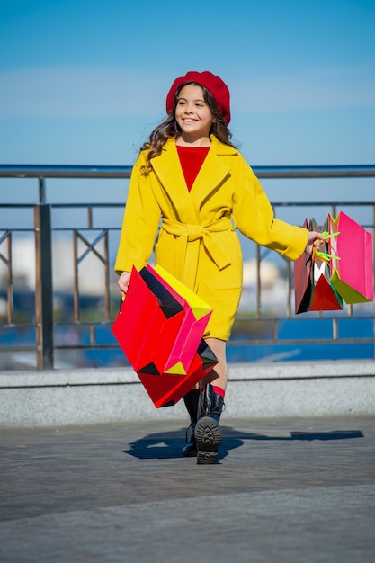 Cheerful teen girl walk with shopping bag autumn shopping teen girl hold shopping bag in autumn