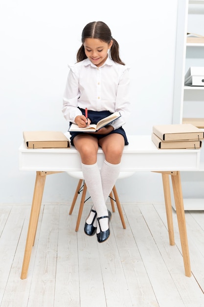 Cheerful teen school girl noting in notebook photo of teen school girl noting