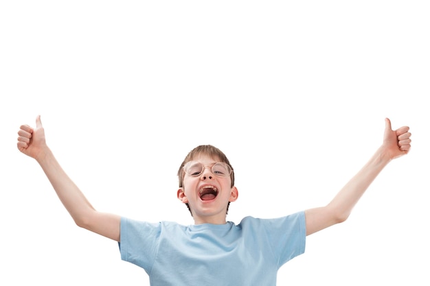 Cheerful teenage boy with glasses raised his hands and points thumbs up Portrait of funny child in isolation on white background