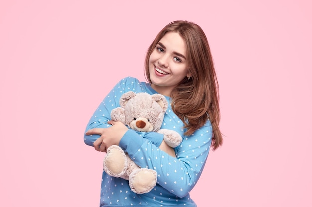 Photo cheerful teenager hugging teddy bear