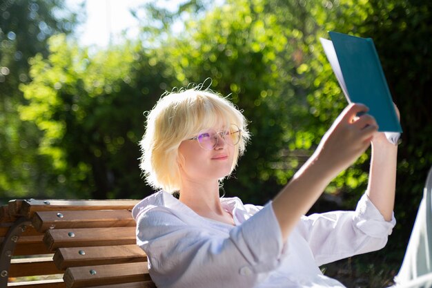 Foto libro di lettura allegro dell'adolescente all'aperto