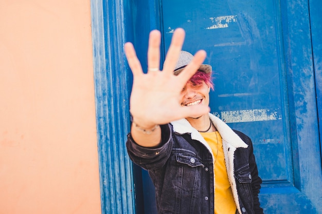 Cheerful teenager smile and put his hands on the camera len to stop the picture