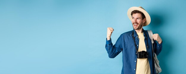 Cheerful tourist rejoicing on vacation celebrating summer holidays showing fist pump gesture and say