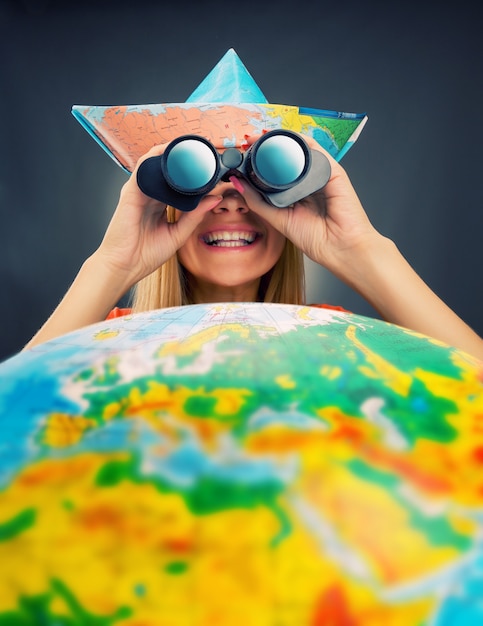 Photo cheerful traveler girl discovering map with binoculars