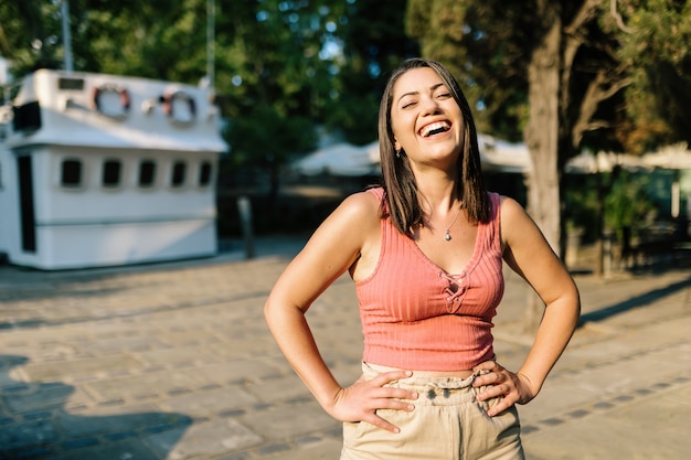 写真 屋外で笑っている陽気なトレンディな女性