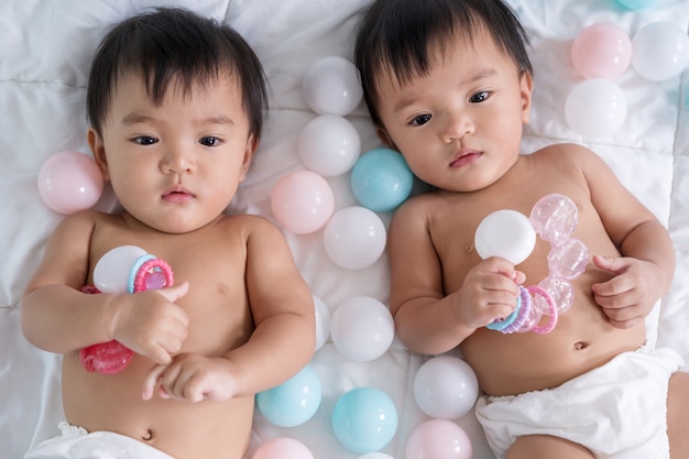 Cheerful twin babies on bed