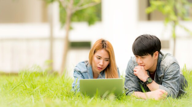 Cheerful university students with laptop on group 