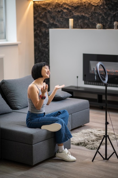 Cheerful vlogger conversing with her digital audience