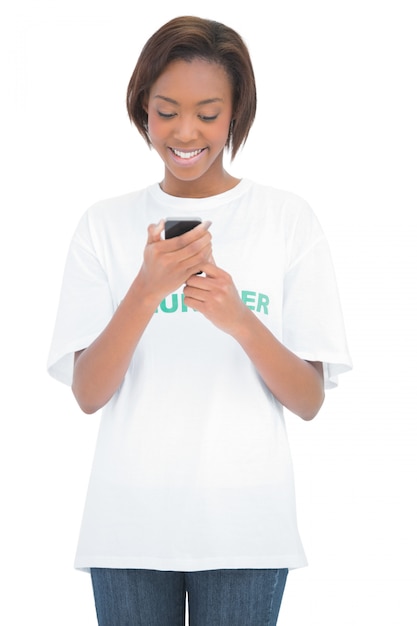 Cheerful volunteer woman looking at her mobile phone