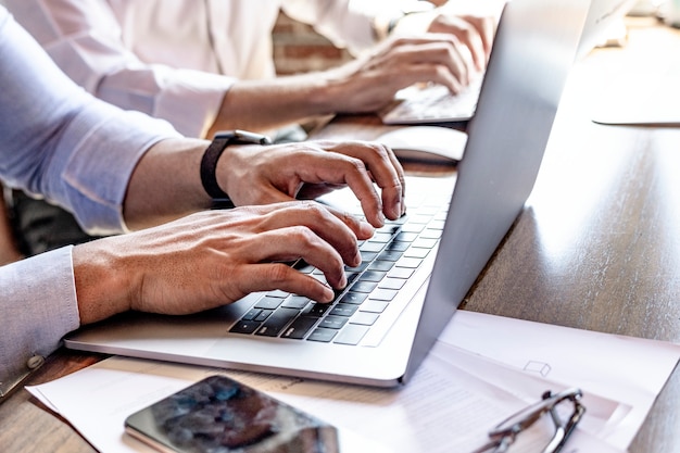 Foto sviluppatori web allegri che lavorano su un laptop