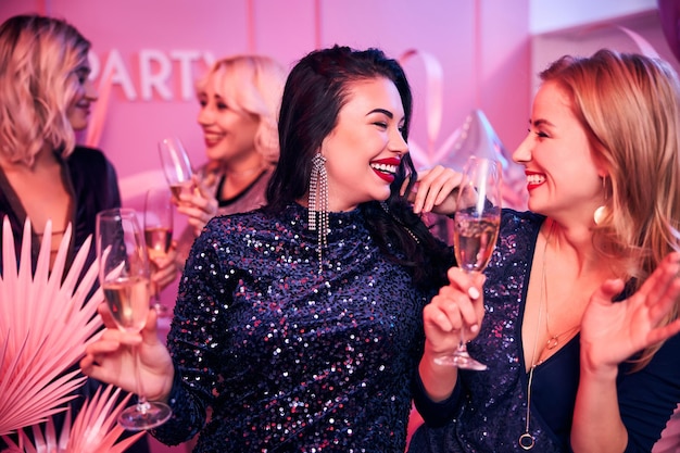 Cheerful well-dressed ladies enjoying their office party