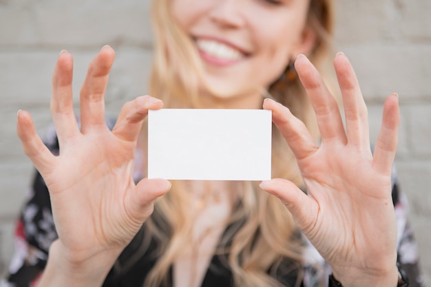 Photo cheerful white woman showing her business card