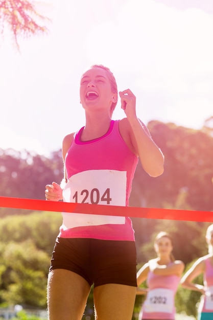 Cheerful winner athlete crossing finish line