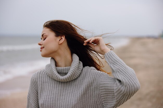 Cheerful woman alone by the ocean cloudy weather Relaxation concept