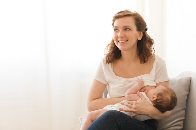 Cheerful woman breastfeeding child