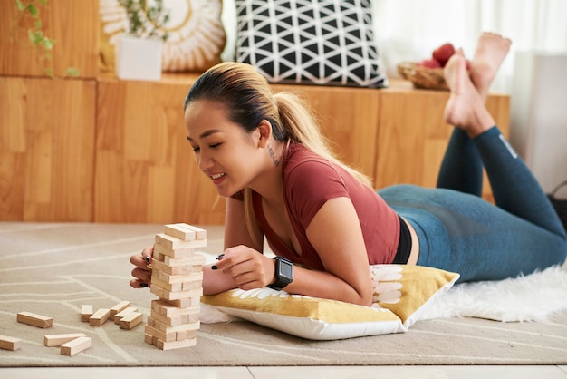 Cheerful woman building tower