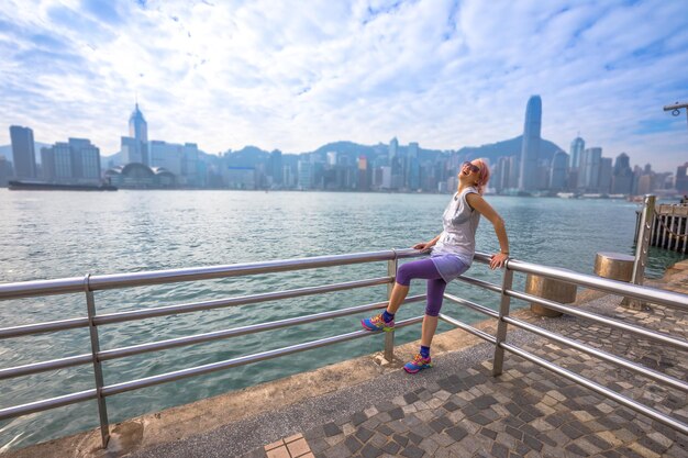 Photo cheerful woman by railing in city against sky