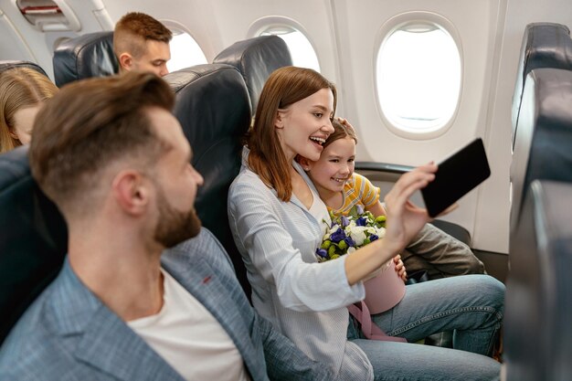 Cheerful woman and child making selfie in airplane