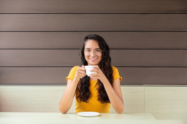 写真 カフェでコーヒーを飲む陽気な女性