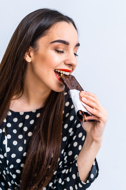 Cheerful woman eating chocolate Cropped photo Closeup Black chocolate with nuts