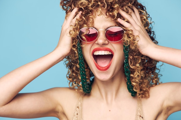 Cheerful woman Emotions hold on to curly hair open mouth sunglasses closeup