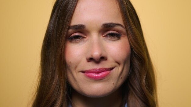 Cheerful woman face on yellow background Happy woman smiling at camera