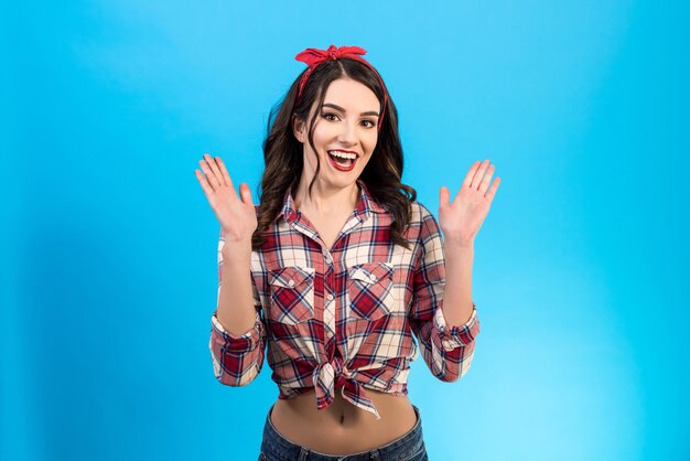 The cheerful woman gesturing on the blue background