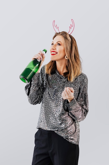 Cheerful woman having a drink with gray background