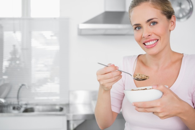 Cheerful woman holding bowl of cereal