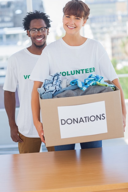 Cheerful woman holding donation box