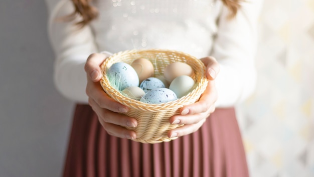 Cheerful woman holding easter eggs in basket