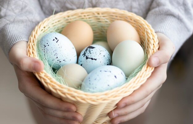 Cheerful woman holding easter eggs in basket