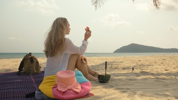 The cheerful woman in holding and eating slices of watermelon on tropical sand beach sea. Portrait attractive girl spend summer weekend.