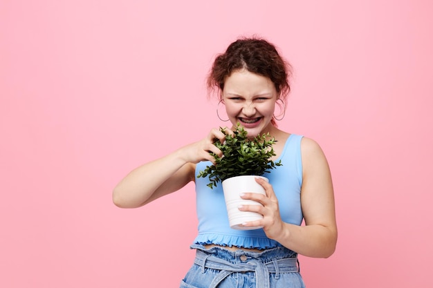 彼女の手に植木鉢を持っている陽気な女性のクローズアップは変更されていません