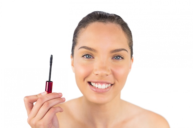 Cheerful woman holding mascara